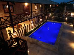 a swimming pool lit up at night with lights at BEACH HOUSE - Loggia Suite 4 - com cozinha - na praia -BEACHFRONT in Barra Grande +30 photos