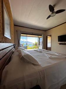a bedroom with a bed with a view of the ocean at Pousada Mariola in Ilhabela +55 photos