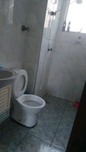 a bathroom with a white toilet and a sink at Praia in Guarujá