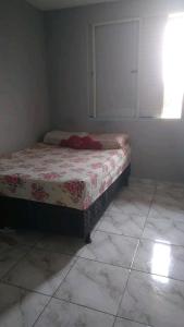 a bedroom with a bed in a room with a window at Praia in Guarujá