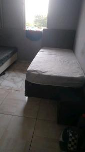 a small bedroom with a bed and a window at Praia in Guarujá
