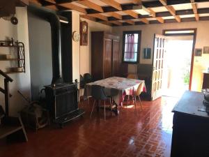 a dining room with a table and a wood stove at La Petite Maison sur la Colline in Chassiers