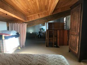 a bedroom with a bed and a wooden ceiling at La Petite Maison sur la Colline in Chassiers