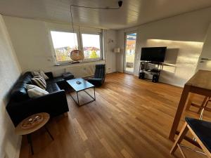 un soggiorno con un divano e un tavolo di Basti's Rooms&Breakfast - Self Checkin a Weil am Rhein