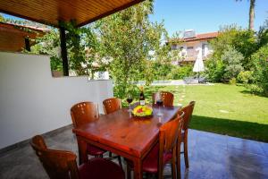 a table with a bottle of wine and a bowl of fruit at Villa Misli - red/ green in Dalyan