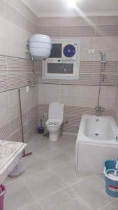ein Badezimmer mit Toilette, Waschbecken und Badewanne in der Unterkunft New capital Shared Rooms men only in Kairo