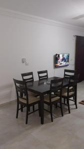 ein schwarzer Tisch und Stühle in einem Zimmer mit einem TV in der Unterkunft New capital Shared Rooms men only in Kairo + 23 Fotos