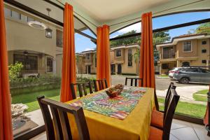 a dining room with a table in front of a window at Villa with Pool, Gated Playas del Coco Getaway in Coco +12 photos