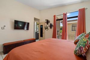 a bedroom with a bed and a flat screen tv at Villa with Pool, Gated Playas del Coco Getaway in Coco