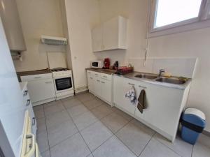 Una pequeña cocina con gabinetes blancos y un fregadero. en Appartement lumineux avec 3 chambres, en Florac 13 fotos más
