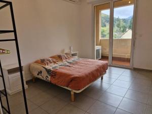 Un dormitorio con una cama y una ventana grande. en Appartement lumineux avec 3 chambres, en Florac