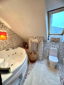 a bathroom with a white tub and a toilet at Exclusive Golden Sands apartment in Riga +36 photos