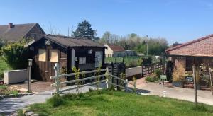 una piccola casa con una recinzione in un cortile di Charmant logement tout confort avec terrasse a Saint-Amand-les-Eaux 1 altra foto