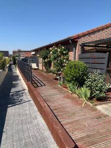 un passaggio in legno di fronte a un edificio in mattoni di Charmant logement tout confort avec terrasse a Saint-Amand-les-Eaux