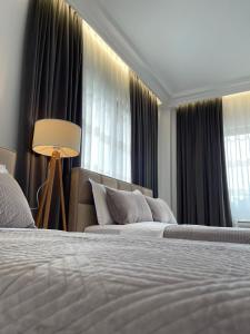 a hotel room with two beds and a window at Guest House Nuhellari 2 in Çorovodë