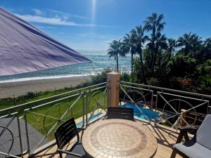 a balcony with a table and chairs and the beach at Exclusive Beachfront Penthouse in Almayate Alto