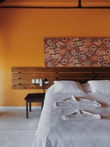 a bedroom with a bed with a painting on the wall at Pousada Mariola in Ilhabela