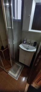 a bathroom with a shower and a white sink at Lavrio center - Thanasis' Studio in Lávrion +10 photos