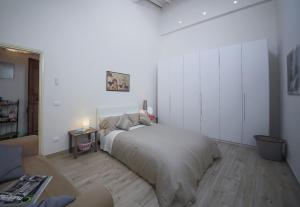 ein weißes Schlafzimmer mit einem großen Bett und einem Tisch in der Unterkunft Apartments Florence Pandolfini Roof in Florenz