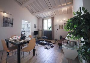 ein Wohnzimmer mit einem Esstisch und ein Wohnzimmer mit einer Pflanze in der Unterkunft Apartments Florence Pandolfini Roof in Florenz