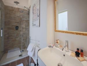 ein Bad mit einem Waschbecken und einer Dusche mit einem Spiegel in der Unterkunft Apartments Florence Pandolfini Roof in Florenz
