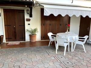 a white table and chairs on a patio at Il Gelsomino - Venice Getaway with Free Parking & Fast Bus in Spinea
