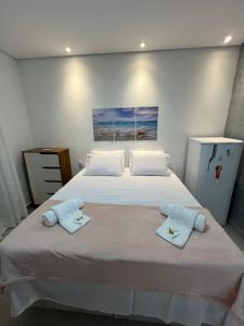 a bedroom with a large bed with two towels on it at Vila flores e mar in São Miguel do Gostoso +16 photos