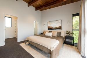a bedroom with a bed and a large window at The Close - House 14 E in Paihia +24 photos