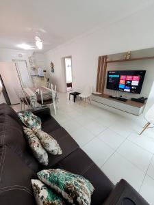 a living room with a couch and a flat screen tv at 201- Apartamento Bombas com vista lateral do mar in Bombas