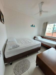 a bedroom with two beds and a window at 201- Apartamento Bombas com vista lateral do mar in Bombas +24 photos