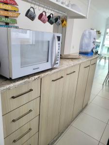 a kitchen with a microwave on a counter at 201- Apartamento Bombas com vista lateral do mar in Bombas