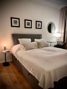 a bedroom with a bed with white sheets and a mirror at ZUHAUSE AM MEER mit Sonnenbalkon in Strand- und Altstadtnähe in Warnemünde
