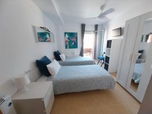 ジローナにあるCENTRICO y ACOGEDOR APARTAMENTOの白いベッドルーム(ベッド2台、ソファ付)