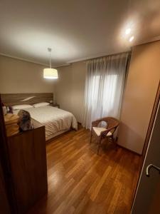 a bedroom with a bed and a desk and a chair at Duplex Playa de Foz in Foz +15 photos