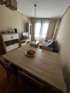 a living room with a table and a couch at Duplex Playa de Foz in Foz