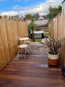 a patio with two chairs and a table and a fence at Les secrets de la baie - La Romana - évasion relaxante Spa privatif in Étaples +2 photos