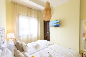 a bedroom with a bed with white sheets and a window at Urban Bliss Guesthouse II in Faro