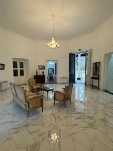 a living room with chairs and a table on a marble floor at Las Magnolias House and Garden in Virrey Toledo