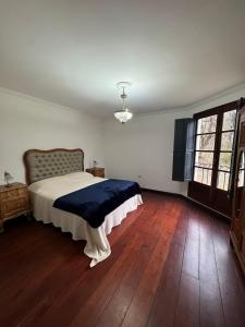 a bedroom with a bed and a wooden floor at Las Magnolias House and Garden in Virrey Toledo