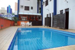 uma piscina no meio de um edifício em Hotel Riviera em São José do Rio Preto