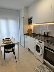 a kitchen with a table and a washing machine in it at Piso Pinar in Santo Domingo de la Calzada