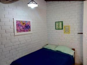 La BocanaにあるHospedaje La Estancia Punta Salの白レンガの壁のベッド1台が備わる客室です。 +26枚の写真