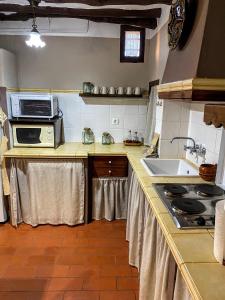 a kitchen with a sink and a microwave at CAN PINÓS de GUIMERÀ in Guimerá +26 photos