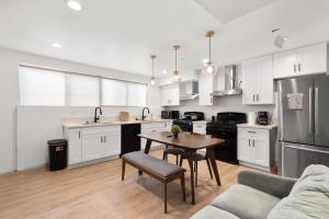 ロサンゼルスにあるPerfect Location Near USC, 1Bedroom with Shared Accessの白いキャビネット、テーブル、ソファ付きのキッチンが備わります。