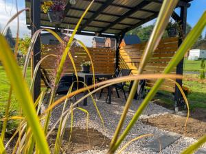 a bench and a table under a pergola at Tiny house u řeky - Bouda Krušnohorka in Vojkovice +6 photos