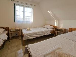 a room with three beds and a window at Vacation Home Miki 2 in Ljuboš