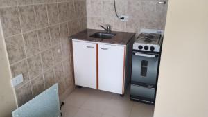 Una pequeña cocina con fregadero y estufa. en Hospedaje 73 M, en Gobernador Gregores 27 fotos más