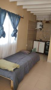 una cama grande en una habitación con ventana en Hospedaje 73 M, en Gobernador Gregores