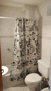 Un baño con inodoro y cortina de ducha. en Hospedaje 73 M, en Gobernador Gregores