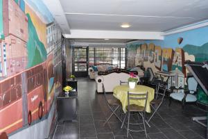 a room with a table and chairs and a mural at Apartamento Heliconia - Casa Tartaruga Bogotá in Bogotá